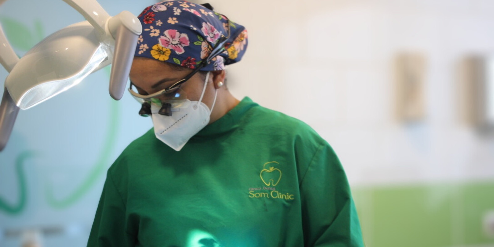 Dentista de Som Clinic atendiendo bajo la l&aacute;mpara del sill&oacute;n