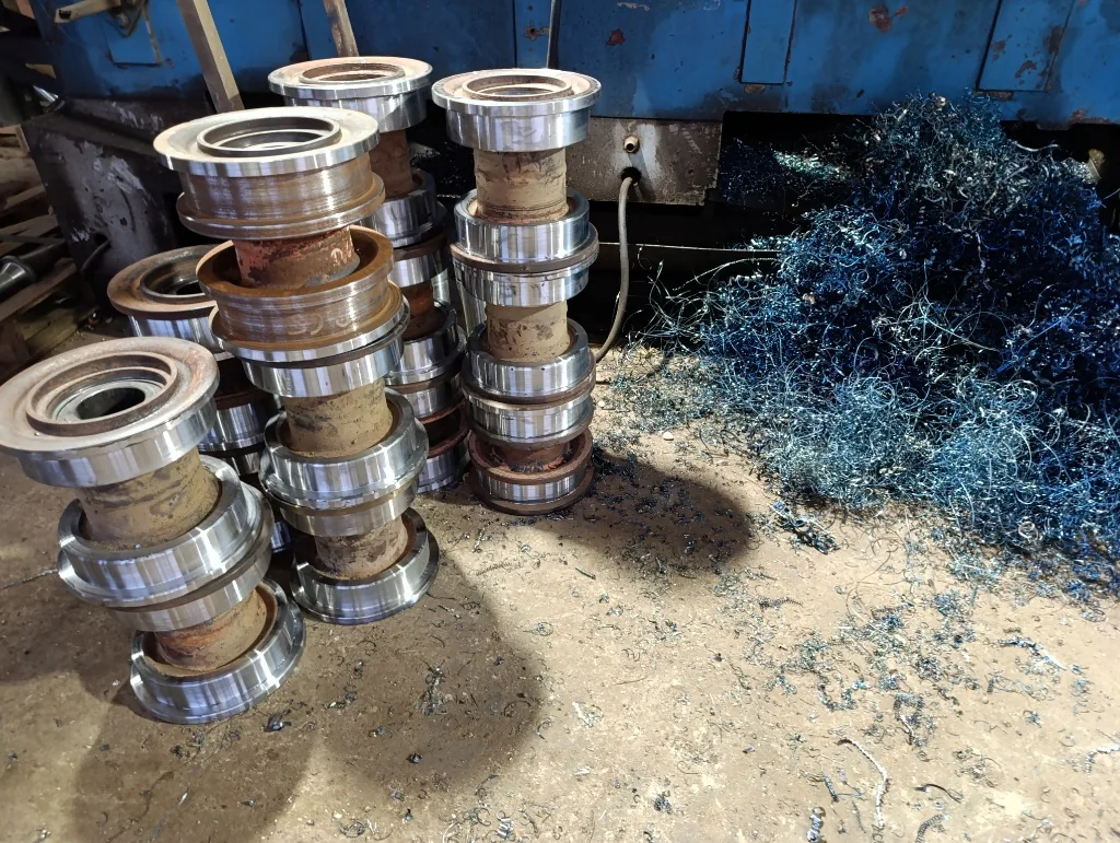 Conjunto de rodillos metálicos rectificados en torno junto a viruta de acero